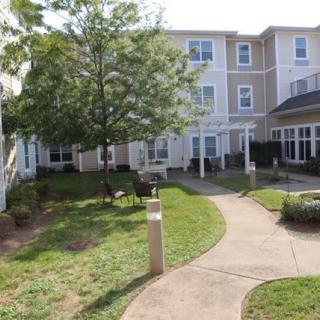 A peaceful courtyard with a walkway, surrounded by a residential building.