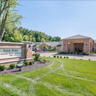 A well-maintained property entrance with a clear sign and landscaped surroundings.