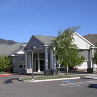 A suburban commercial building with a parking lot in daylight.