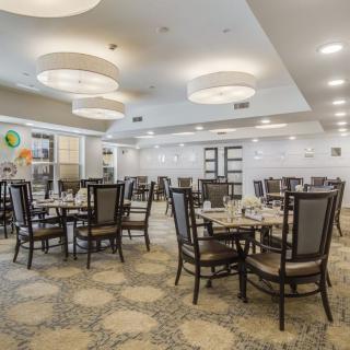 A well-lit, empty dining area with neatly arranged tables and chairs.