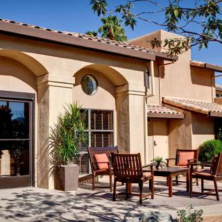 A Mediterranean-style building with outdoor seating on a sunny day.