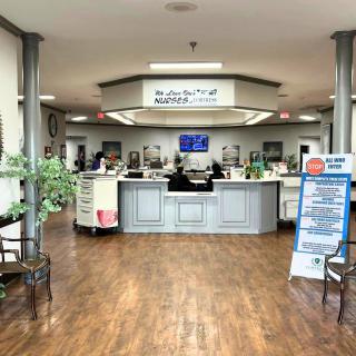 This image shows a hospital lobby with a reception desk and waiting area.