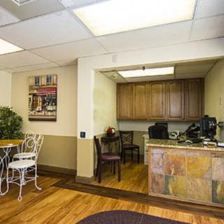 A cozy office reception area with a desk, chairs, and decorative elements.