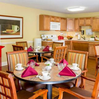 A cozy dining area with a set table and an adjacent kitchen.