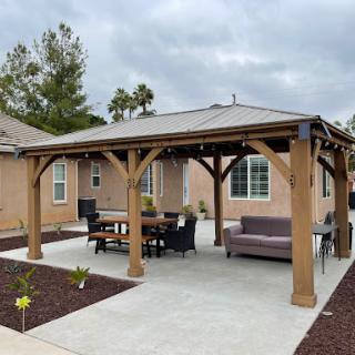A stylish outdoor patio area featuring a wooden pergola and comfortable seating, perfect for relaxation or gatherings.