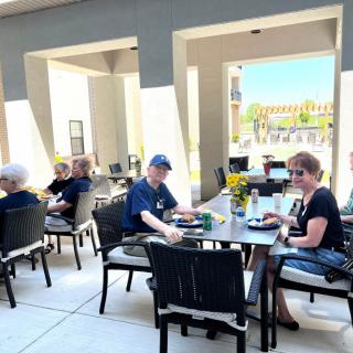 People enjoying a meal on an outdoor patio at a restaurant.