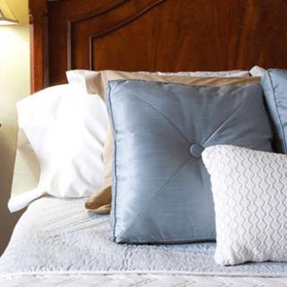 A cozy bed adorned with decorative pillows and cushions.