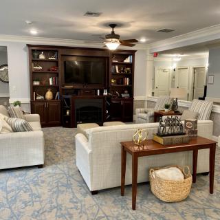 A cozy living room featuring comfortable seating, a central table, and built-in bookshelves surrounding a television.