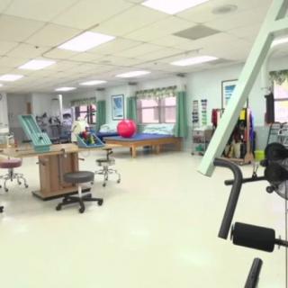 A spacious therapy and fitness center equipped with exercise machines and rehabilitation tools.