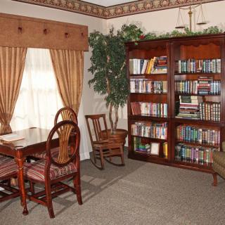Cozy reading room with a wooden bookshelf and seating area.