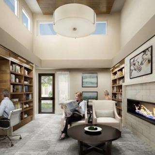 A modern living room with high ceilings, bookshelves, and a cozy fireplace.