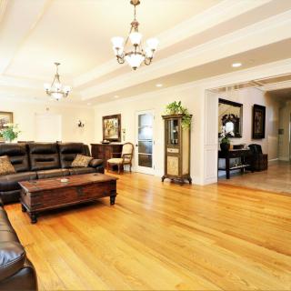 A spacious living room featuring elegant decor, hardwood floors, and comfortable seating.