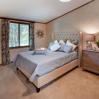 A cozy bedroom with a stylish bed, soft lighting, and elegant decor.
