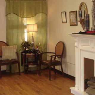 A cozy living room with elegant furniture and a decorative fireplace.