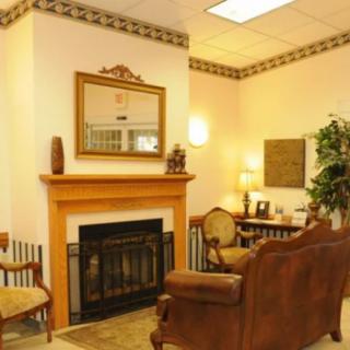A cozy living room with a traditional design featuring a fireplace and wooden furniture.