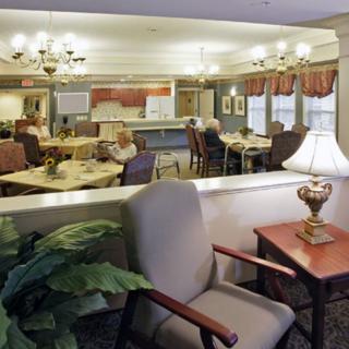 A cozy dining area with tables, chairs, and warm lighting.