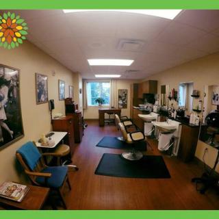 A cozy barbershop interior with styling chairs, posters on the walls, and hairdressing equipment.