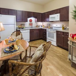 A cozy kitchen and dining area with wooden cabinets, set for a meal.