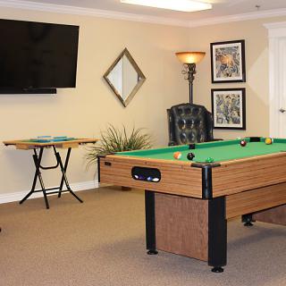 A well-furnished game room featuring a pool table and television.
