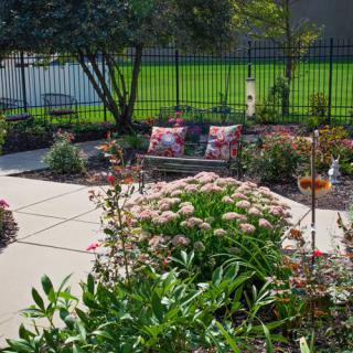 A beautifully landscaped backyard garden with colorful flowers and outdoor seating.