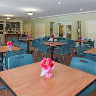 A well-arranged dining area featuring tables adorned with flowers, designed for community gatherings.