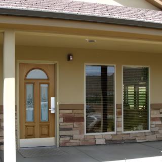 A small storefront with a wooden door and two large windows.