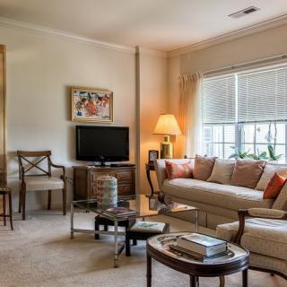 A cozy living room with a sofa, television, and ample natural light.