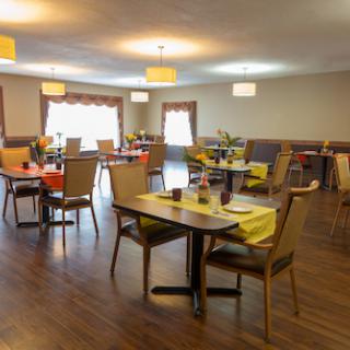 A spacious and inviting dining area with elegantly set tables and warm lighting.