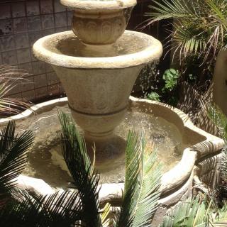 A decorative garden fountain surrounded by lush plants.