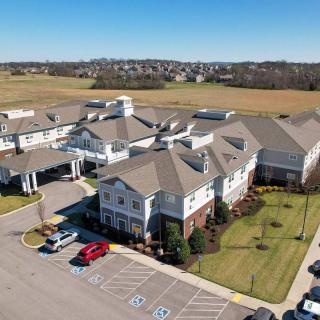 Aerial view of a large building with surrounding parking and landscaped areas.