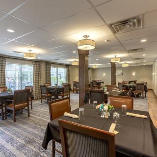 A well-arranged dining area with neatly set tables and soft lighting.