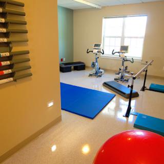 A well-equipped fitness room featuring exercise bikes, yoga mats, and a large exercise ball.