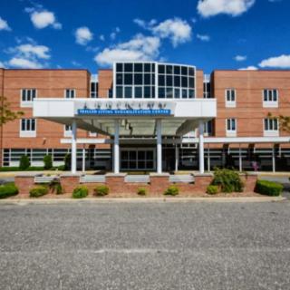 Front view of a hospital building with a clear blue sky.