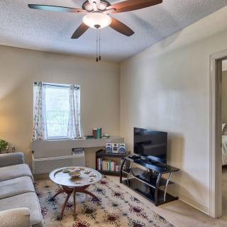 A cozy living room with a sofa, television, and coffee table under a ceiling fan.