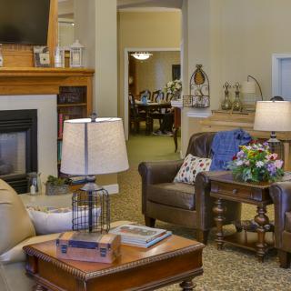 A cozy living room with comfortable seating, a fireplace, and elegant lamps.