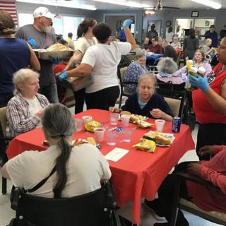 A community gathering of seniors enjoying a meal together in an indoor setting.