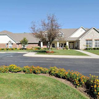 A suburban residential house with a well-maintained lawn and colorful flowers.