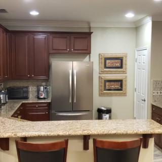A modern kitchen with a granite countertop and stainless steel appliances.