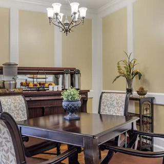 Elegant dining room with a wooden table, upholstered chairs, and a chandelier.