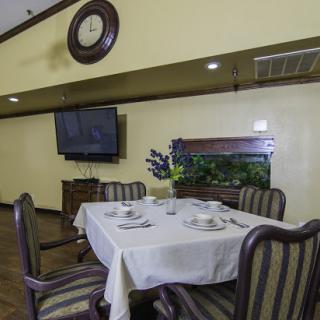 A cozy dining room featuring a neatly arranged table, comfortable chairs, and modern amenities.
