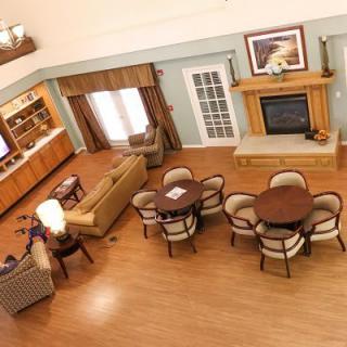 An overhead view of a spacious living room featuring elegant furniture, wood flooring, and a cozy fireplace.