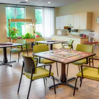 A cozy dining area with modern furniture, indoor plants, and ample natural light.