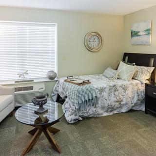 A cozy bedroom with modern decor, featuring a bed, sofa, and coffee table.