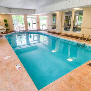 An inviting indoor swimming pool surrounded by tiled flooring, perfect for relaxation.