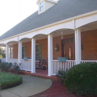 A charming house with a covered porch and white columns.