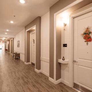 A well-lit hallway with decorative doors and wooden flooring.