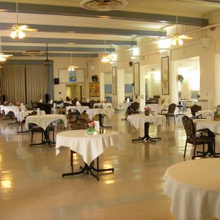A spacious and elegantly arranged restaurant dining area with round tables and chairs.