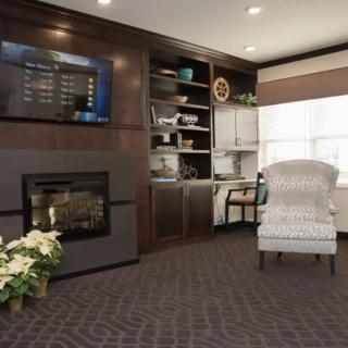 A cozy living room featuring a fireplace, television, and comfortable armchair.