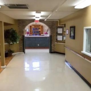 A clean and well-lit hallway leading to an entrance with a decorated archway.