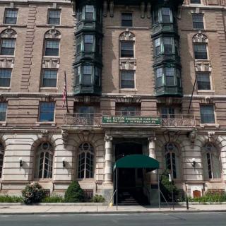 A historic hotel building with classic architectural design and a green entrance canopy.